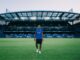Morgan Rogers stojący na tle trybun i płyty boiska stadionu Stamford Bridge w Londynie.